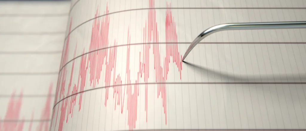 Earthquake seismograph paper with a stylus pen recording large activity variations.