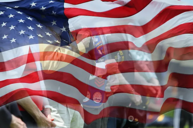 Flag of the United States with images of veterans faded into the lower background.