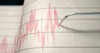Earthquake seismograph paper with a stylus pen recording large activity variations.