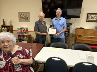 Ken Flory, right, receives the 2024 Volunteer of the Year plaque from Eads Chamber of Commerce President Dennis Pearson. Left: Doris Lessenden