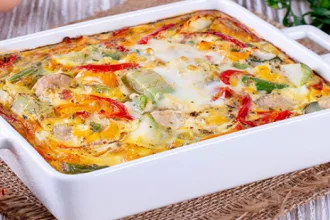 Ceramic baking dish of polenta with pepper and cheese.