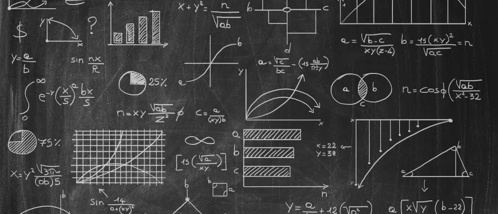 Chalk board with formulas, graphs, and charts.