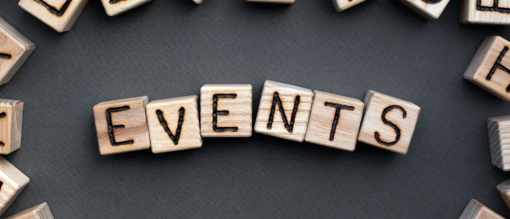 Assorted wooden block with letters on the sides, surrounding the word "events" on wooden blocks