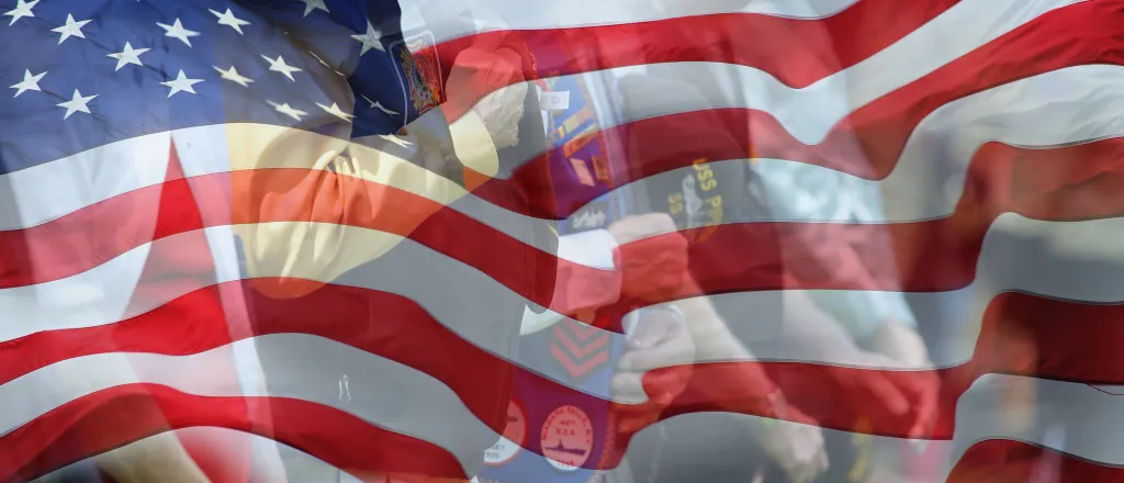 Flag of the United States with images of veterans faded into the lower background.