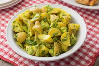 Bowl of potato salad on a checkered cloth.