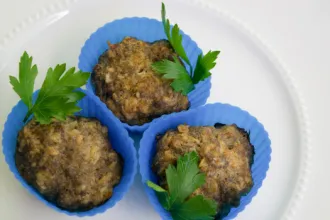Plate with three savory meatloaf muffins in muffin cups.